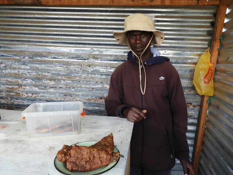 レソトの観光と食べ物 セモンコンで魚フライを売る人