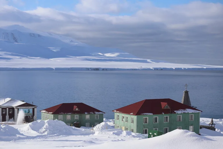バレンツブルグの街並みと背景に広がる氷雪のフィヨルド(Barentsburg townscape with Arctic fjord view)