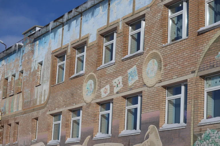 スバールバル諸島のバレンツブルグにある学校の外観と壁に架かれたアート