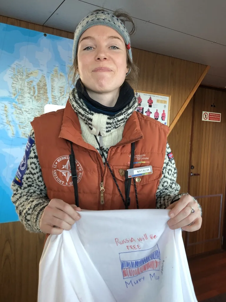 スバールバル諸島のバレンツブルグにいるロシア人の観光ガイド。手に世界平和と記した旗を持つ。