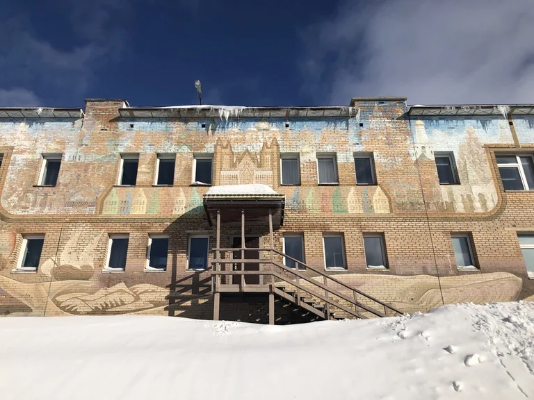 スバールバル諸島のバレンツブルグにある学校の外観と壁に架かれたアート