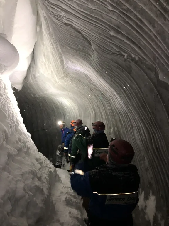 スヴァ―ルバル諸島の氷の洞窟の中を探検する人たち