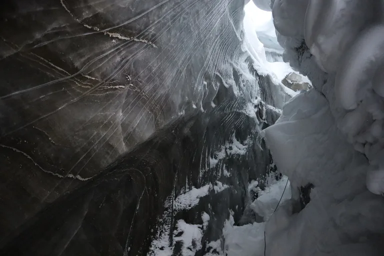 スヴァ―ルバル諸島の氷の洞窟の中を探検する人たち