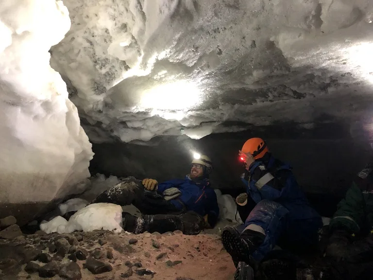 スヴァ―ルバル諸島の氷の洞窟の中を探検する人たち
