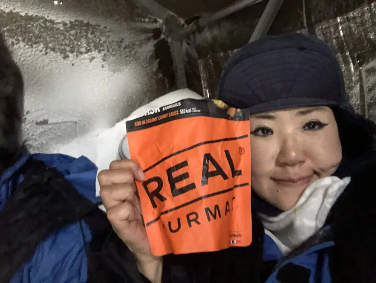 スヴァ―ルバル諸島の北極キャンプで簡易食を食べる人