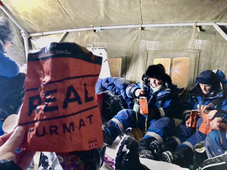 スヴァ―ルバル諸島の北極キャンプで簡易食を食べる人