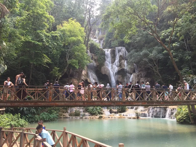 クアンシーの滝（Kuang Si Waterfall） の前の展望デッキから写真を撮る観光客