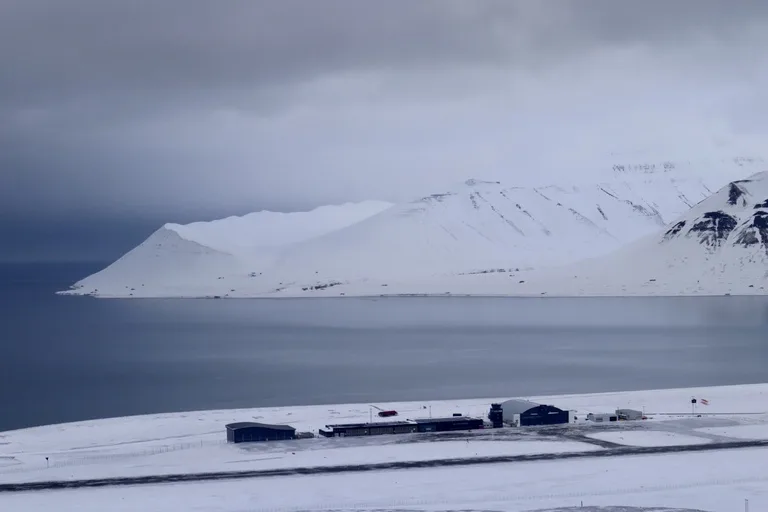 Svalbard Global Seed Vault(スヴァールバル世界種子銀行)から眺める港と背後に雪山の景色