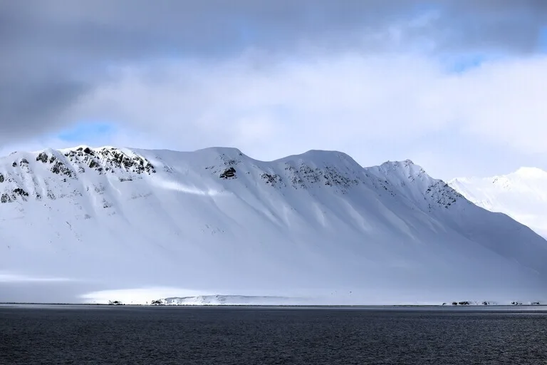 Spitsbergen島のブルーライトに染まったフィヨルドの氷山