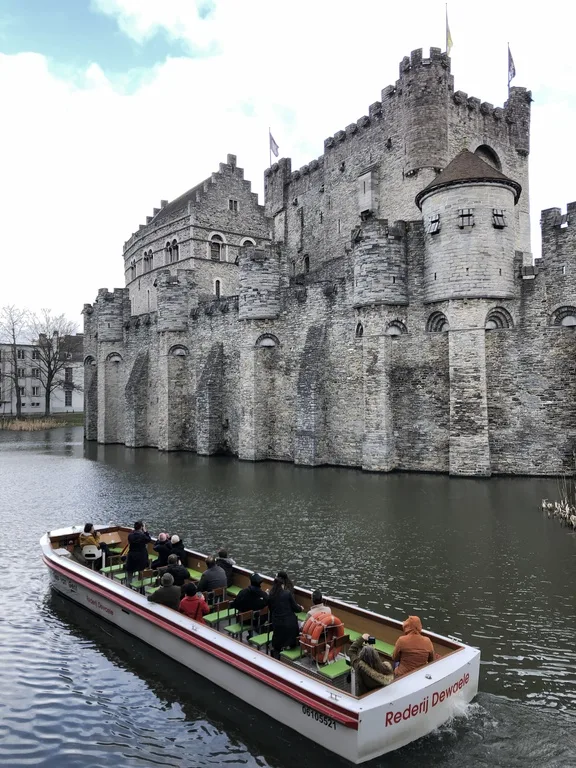 ベルギーのゲントにあるフランドル伯居城とリバークルーズを楽しむ人たち
