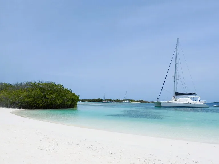 ロスロケス諸島の青い海と白い砂浜に停泊するボート