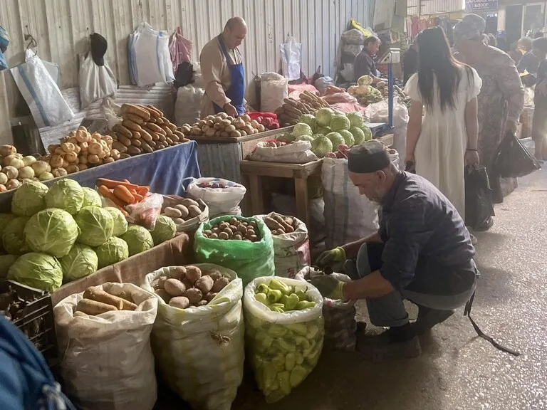 タジキスタンのマーケットで野菜を売る老人