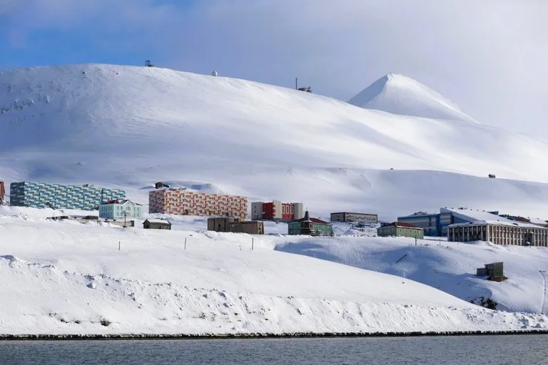 バレンツブルグの街並みと背景に広がる氷雪のフィヨルド(Barentsburg townscape with Arctic fjord view)
