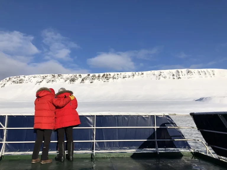 ロングイェールビーンからバレンツブルグに行くフェリーで雪山を眺めながら寄り添う老夫婦の後ろ姿