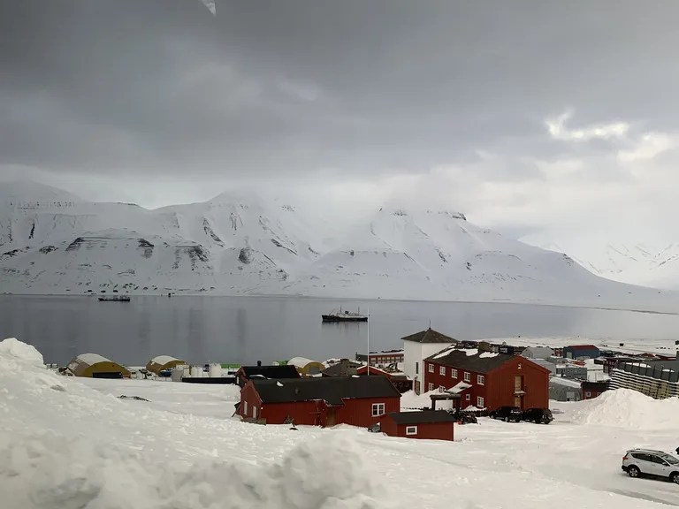 冬のスヴァールバルで雪景色の中、港に入る船（北極圏の風景）