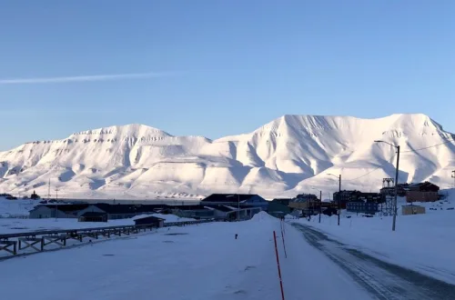 北極圏ロングイェールビーン(Longyearbyen)の町中心へ向かう道と奥に雪山が広がる風景