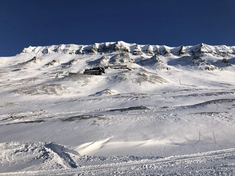 北極圏ロングイェールビーン(Longyearbyen)の雪原と背後に雪山が広がる風景
