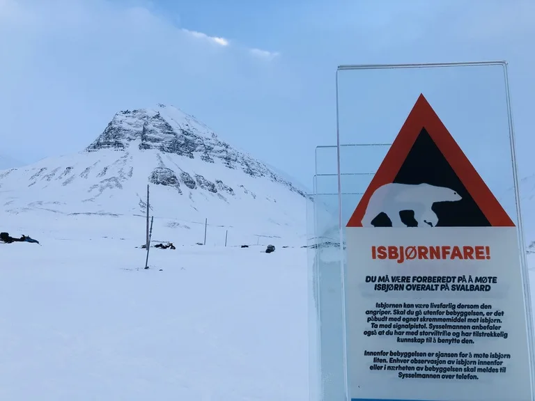 北極圏ロングイェールビーン(Longyearbyen)の雪山とホッキョクグマ注意の看板