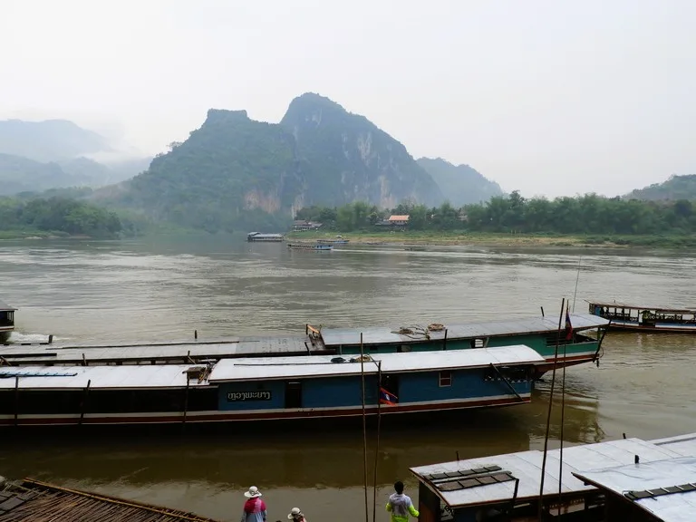 パークウー洞窟の船着き場に停泊するロングボートとメコン川の風景