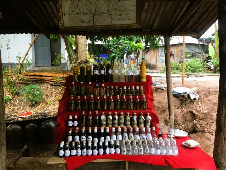サーンハイ村で作られた蒸留酒(ラオラオ)を並べた棚
