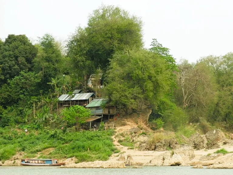 メコン川クルーズ中に見える川沿いの漁村風景
