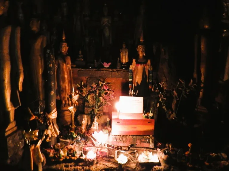 パークウー洞窟(Pak Ou Caves)の奥深く、ろうそくの明りで灯しだされるたくさんの仏像