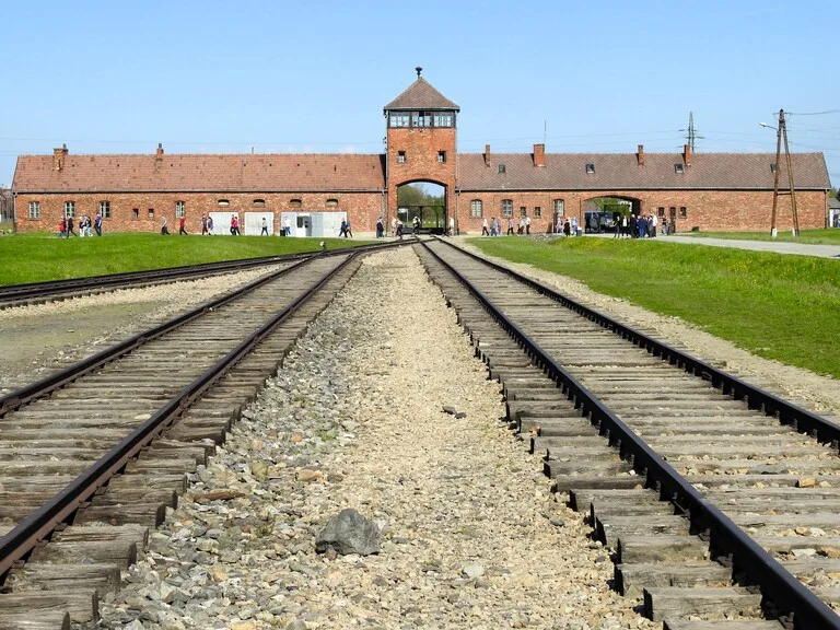 ポーランドにあるアウシュヴィッツ=ビルケナウ強制収容所の正面と、そこにまっすぐのびる線路