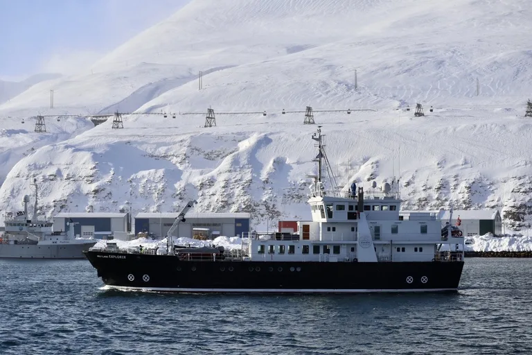 スピッツベルゲン島のロングイェールビーンの港に停泊する船と雪山の風景