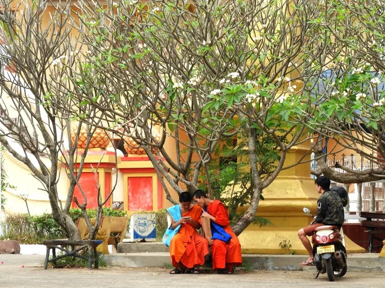 ラオス、ビエンチャンの木陰で話をする僧侶たち