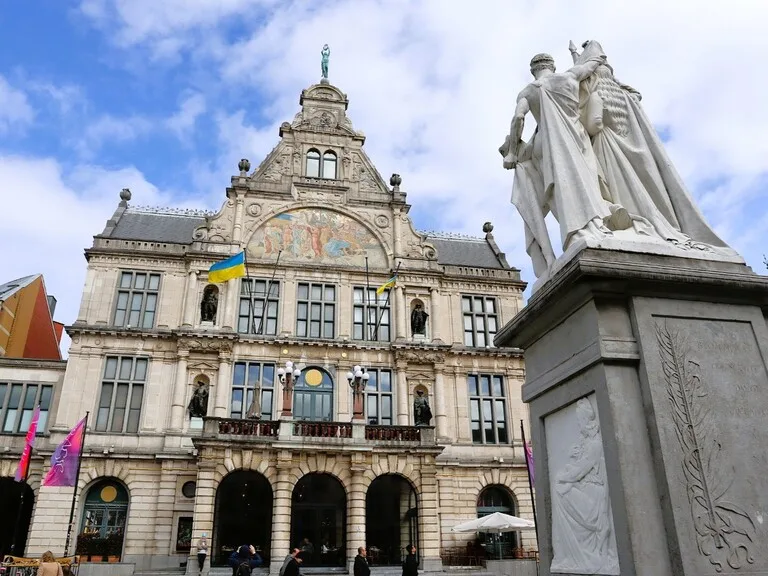 ゲントの歴史的建築物とカップルの像