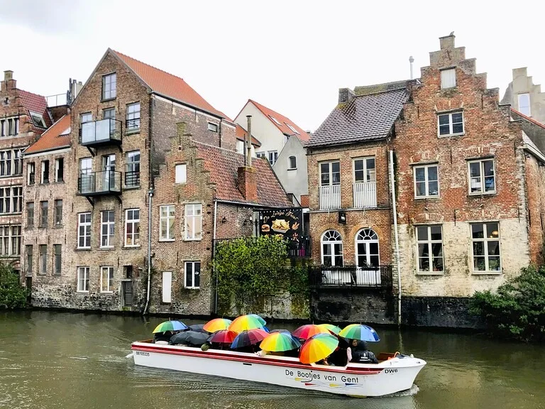 ベルギーのゲントで傘をさしてボートクルーズをする風景