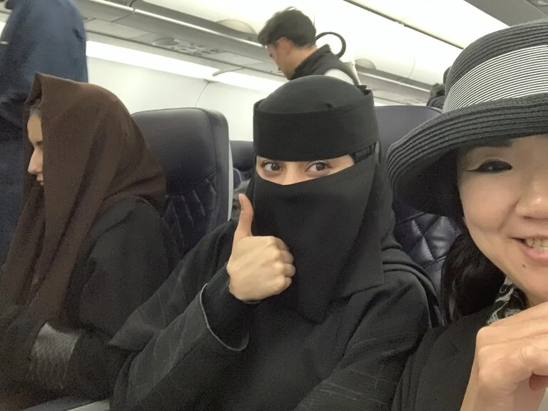 サウジアラビアの女の子と記念撮影する観光客