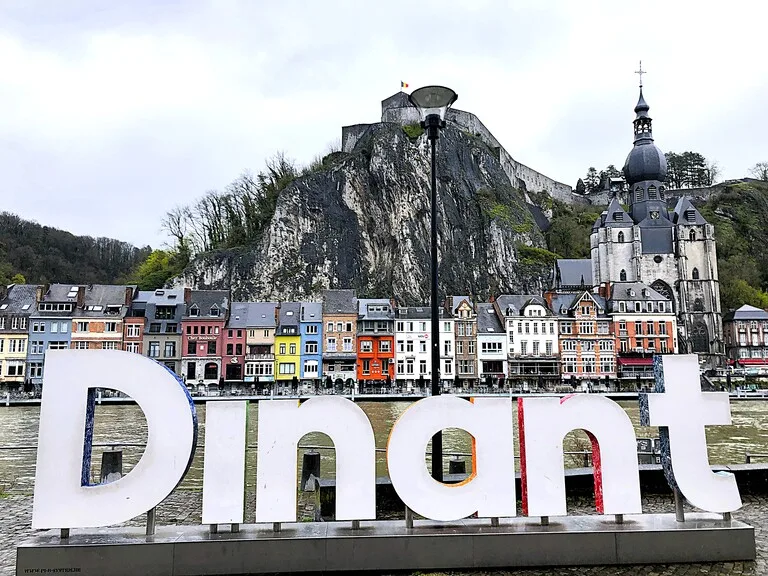 ベルギー・ディナン城塞（Citadel of Dinant）と街並みを背景にした「Dinant」の文字サイン