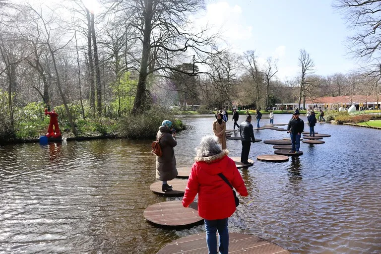 キューケンホフ公園の湖に設置された飛び板で遊ぶ来園者
