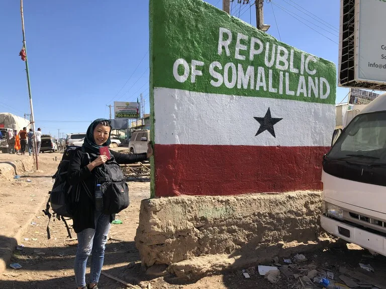 ソマリランドの看板とバックパックを背負った旅人(私)