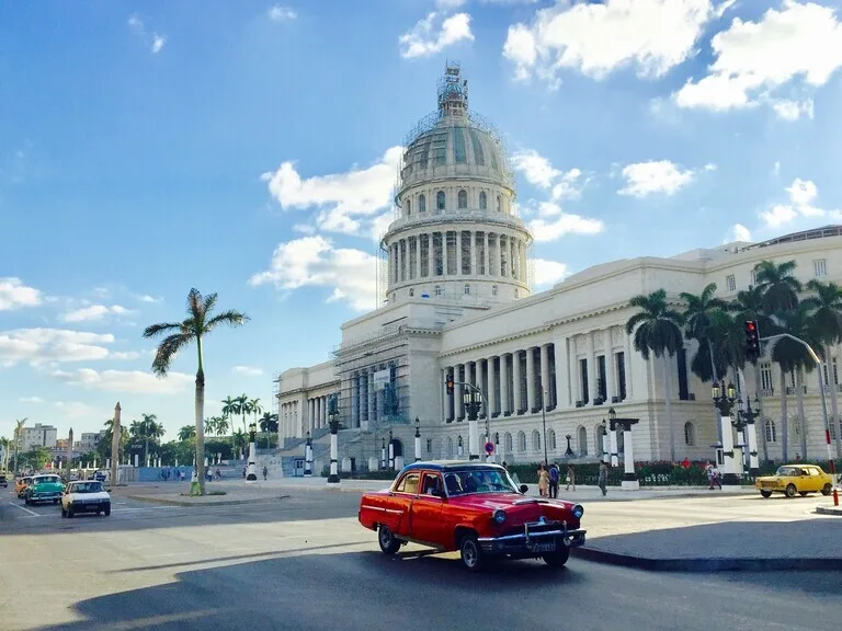 ハバナのEl Capitolioの前を走り抜けるクラッシックカー