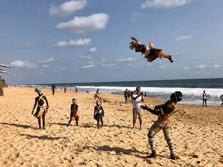 グランバッサムのビーチで子どもを空中に投げる大道芸人